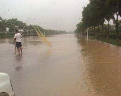 南京大雨道路積水 城管駕執(zhí)法車去捕魚